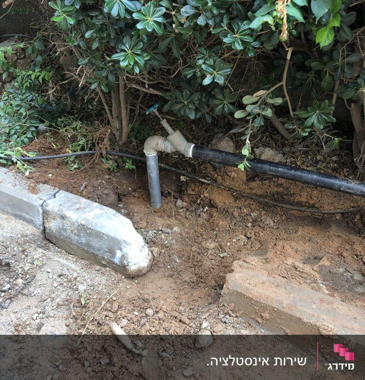 צינור מים שחור עם ברז בגינה